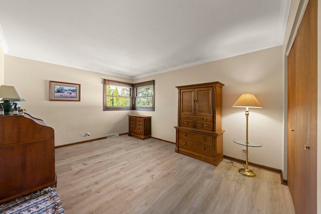 interior space with ornamental molding, light wood finished floors, and baseboards