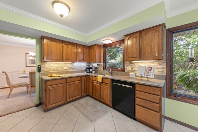 kitchen featuring ornamental molding, black dishwasher, brown cabinets, and a sink