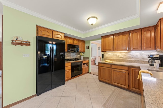 kitchen with light tile patterned floors, black appliances, ornamental molding, and brown cabinetry