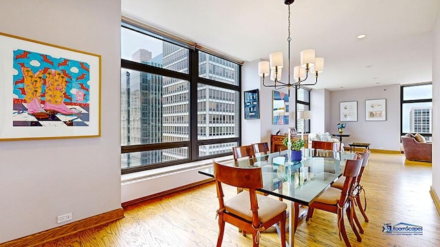 dining room with light wood-type flooring, an inviting chandelier, baseboards, and recessed lighting