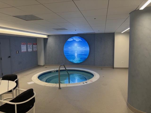 view of pool with an indoor hot tub