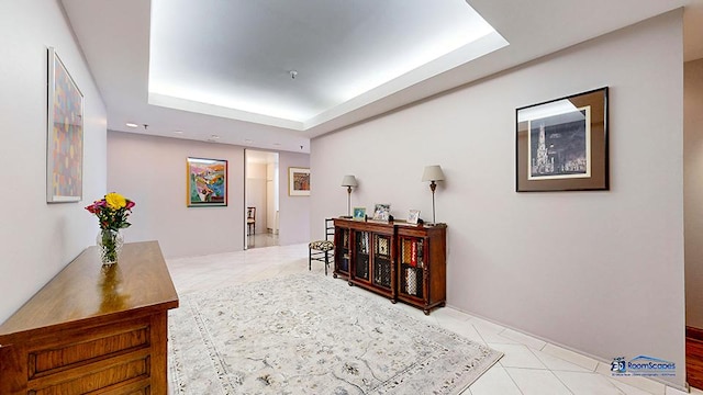 corridor featuring tile patterned flooring and a raised ceiling