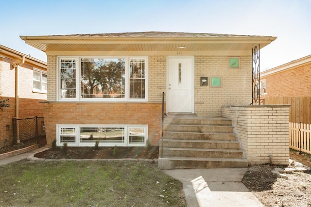 view of front facade featuring fence and brick siding