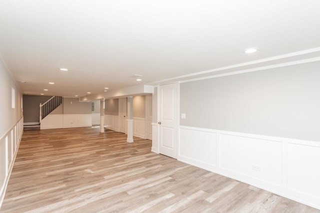 spare room with light wood finished floors, stairway, a wainscoted wall, and recessed lighting