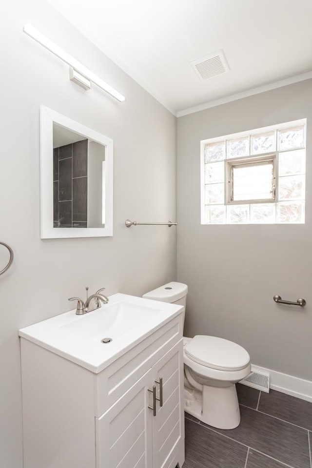 bathroom with toilet, baseboards, visible vents, and vanity