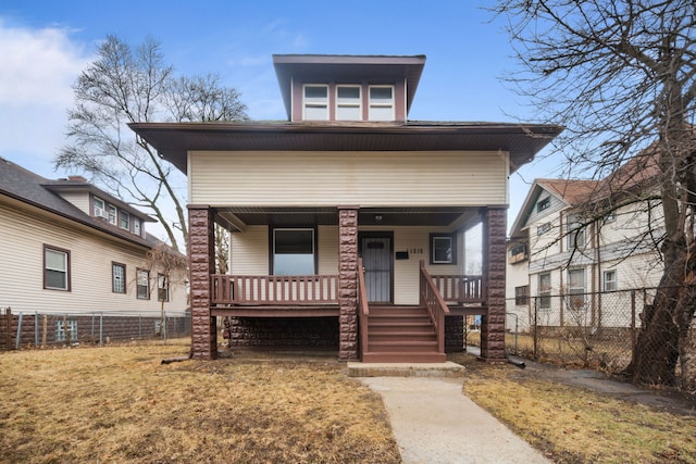 view of front facade with a porch, fence private yard, and a front yard