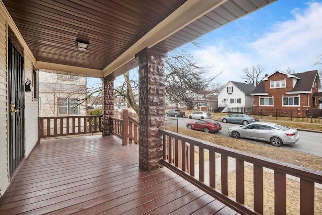 wooden deck with covered porch and a residential view