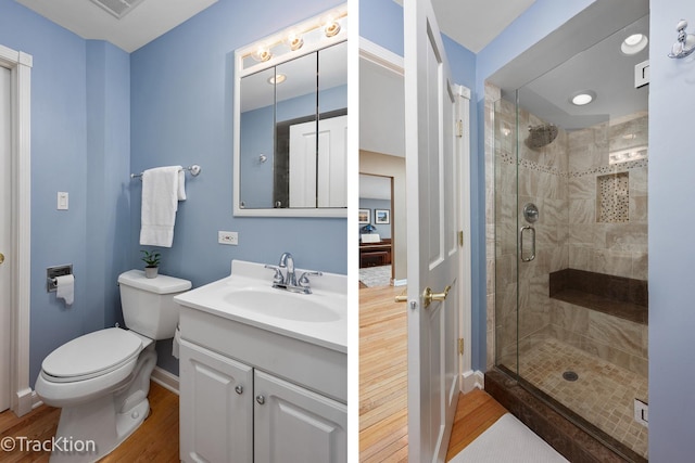 bathroom with toilet, a stall shower, wood finished floors, baseboards, and vanity