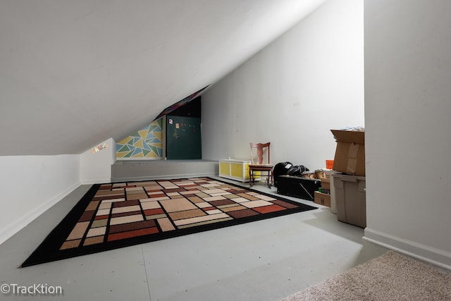 additional living space featuring baseboards, lofted ceiling, and finished concrete floors