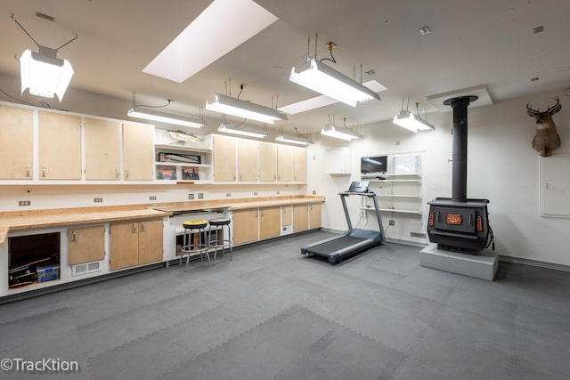 exercise area featuring a wood stove and baseboards