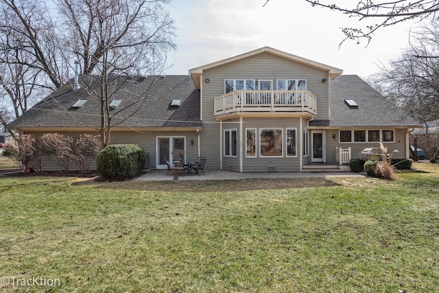 rear view of house featuring a yard, a balcony, roof with shingles, and a patio area