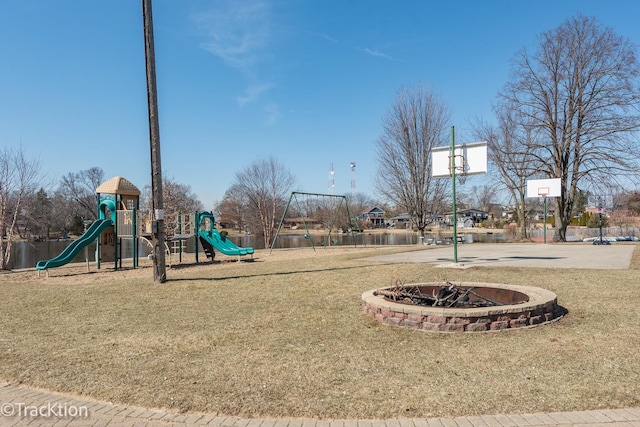 community play area featuring a lawn and community basketball court