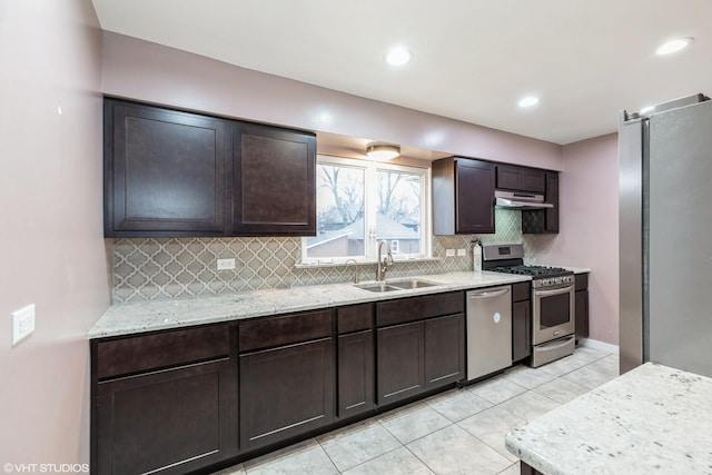 kitchen featuring appliances with stainless steel finishes, a sink, dark brown cabinetry, and decorative backsplash