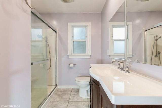 bathroom featuring toilet, a stall shower, baseboards, and vanity