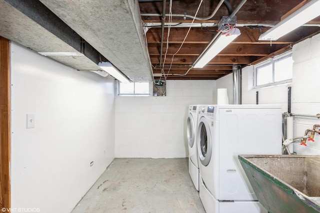 laundry area featuring laundry area, plenty of natural light, separate washer and dryer, and a sink