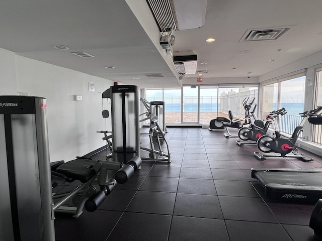 workout area featuring a wall of windows, visible vents, and plenty of natural light