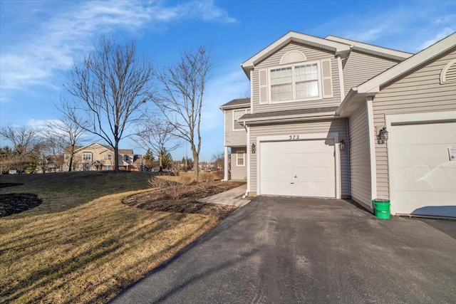 view of side of property featuring driveway and a yard