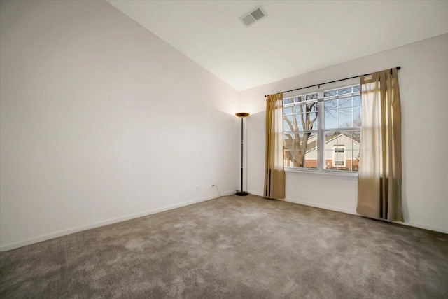 spare room featuring visible vents, baseboards, lofted ceiling, and carpet floors