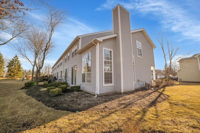 view of property exterior with a lawn and a chimney