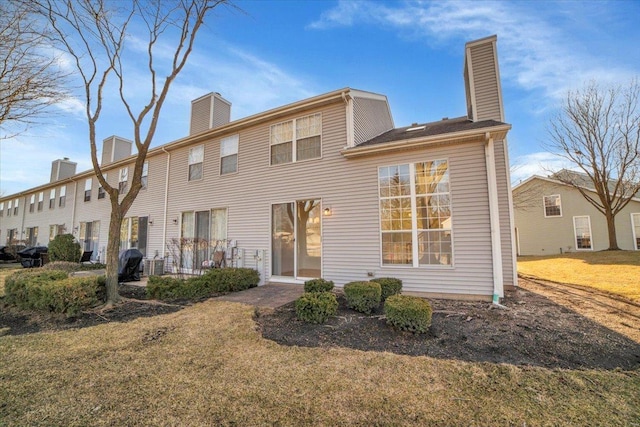 rear view of property with a lawn and a chimney