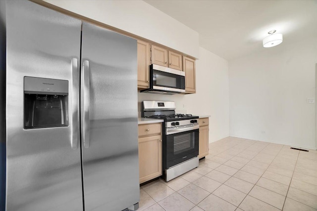 kitchen with light tile patterned floors, stainless steel appliances, light brown cabinets, and light countertops