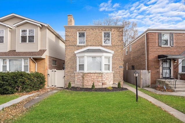 view of front of property featuring a chimney, a gate, fence, a front yard, and brick siding