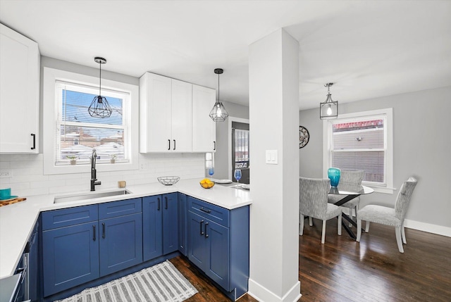 kitchen with dark wood-type flooring, a sink, white cabinetry, and blue cabinets