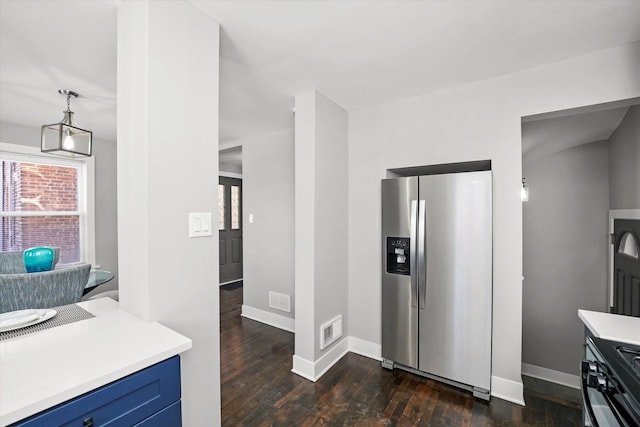 kitchen with blue cabinets, dark wood-type flooring, visible vents, light countertops, and stainless steel refrigerator with ice dispenser