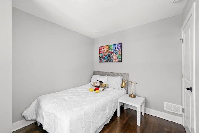 bedroom featuring wood finished floors, visible vents, and baseboards