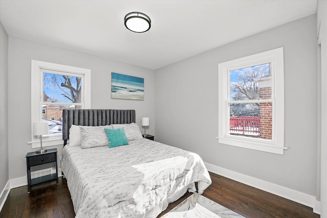 bedroom with dark wood-type flooring and baseboards