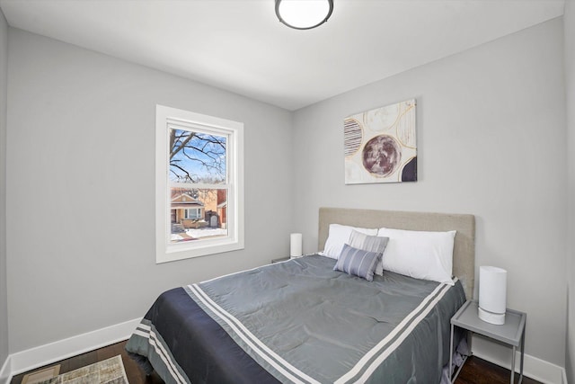 bedroom featuring dark wood-style flooring and baseboards