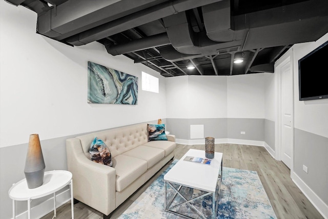 living room featuring baseboards, visible vents, and wood finished floors