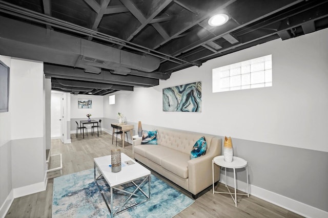 living area featuring wood finished floors, visible vents, and baseboards