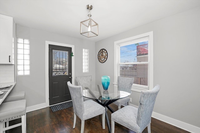 dining room with plenty of natural light, baseboards, and dark wood-type flooring