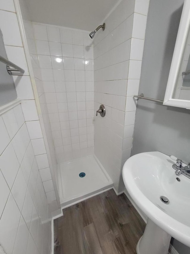 bathroom with a stall shower, a sink, and wood finished floors