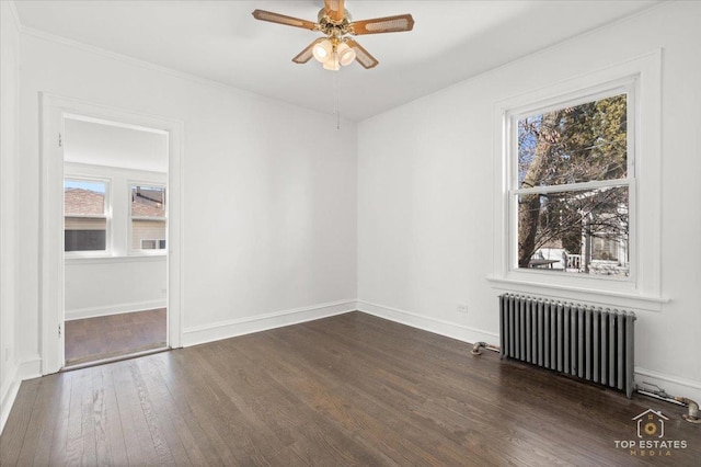 empty room with dark wood finished floors, ceiling fan, radiator heating unit, and baseboards