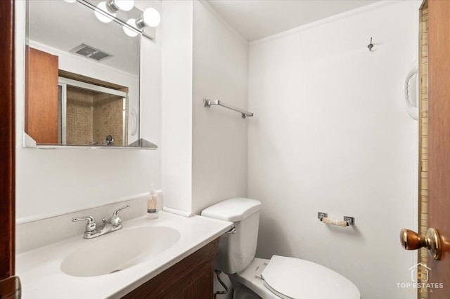 bathroom with visible vents, toilet, vanity, and crown molding