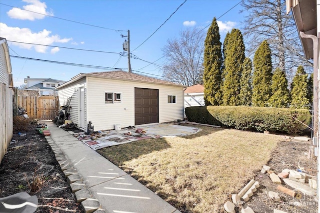 exterior space featuring an outbuilding, a garage, and fence