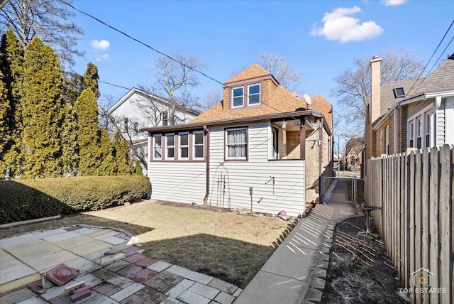 exterior space featuring a patio, fence, and roof with shingles