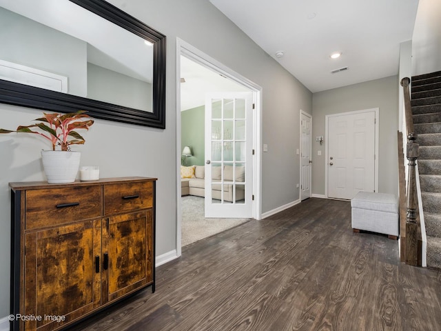 foyer entrance with stairway, baseboards, and dark wood-type flooring