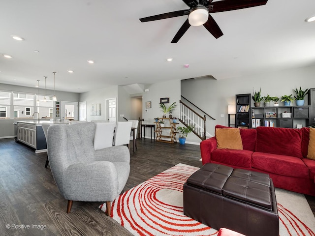 living area featuring ceiling fan, baseboards, stairway, recessed lighting, and dark wood-style flooring