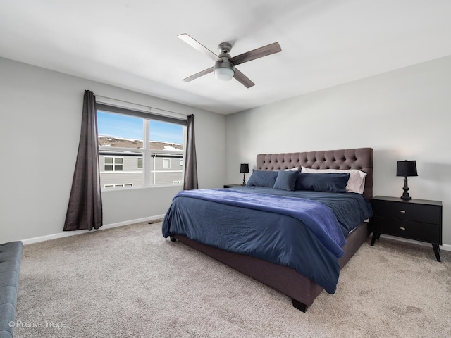 bedroom featuring light colored carpet, a ceiling fan, and baseboards