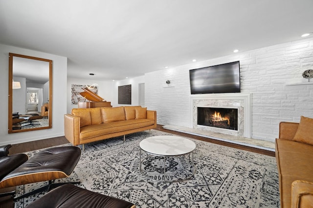 living area with recessed lighting, wood finished floors, and a high end fireplace