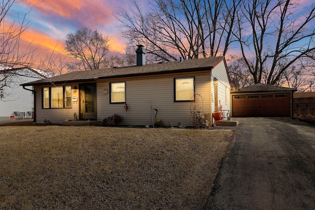 ranch-style home with an outbuilding, a detached garage, and a front lawn