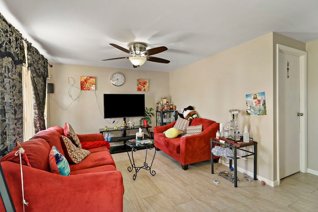 living room with baseboards and a ceiling fan