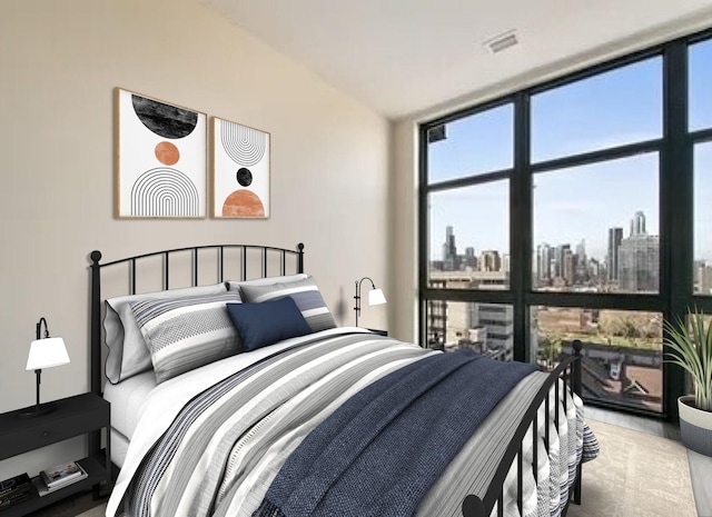 bedroom featuring a city view, lofted ceiling, visible vents, and expansive windows