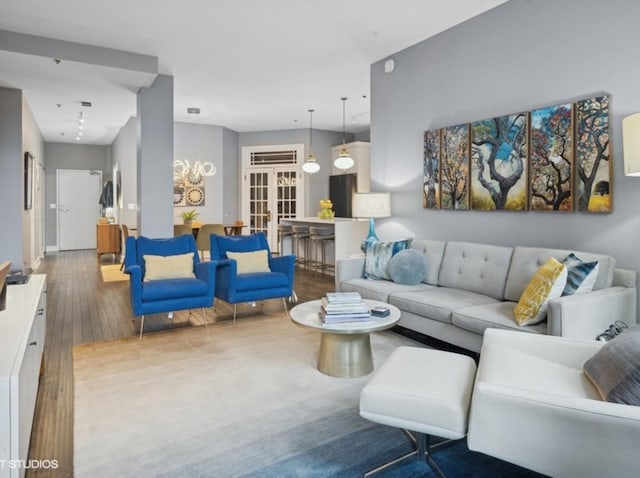 living area with french doors and wood-type flooring