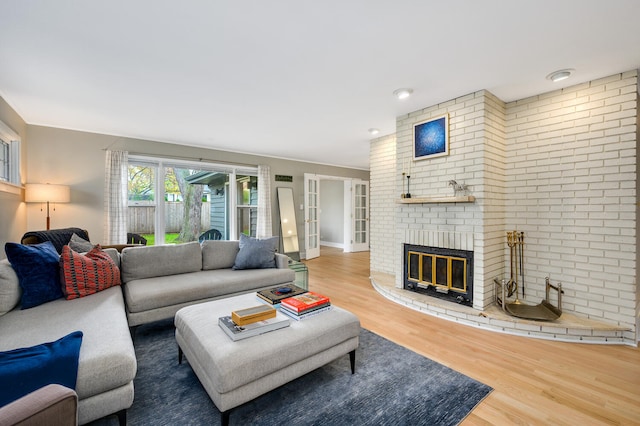 living area with a brick fireplace and wood finished floors