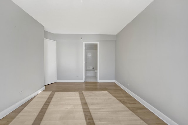 unfurnished room with baseboards and light wood-style floors