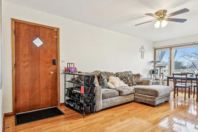 living area with a ceiling fan and light wood-style floors